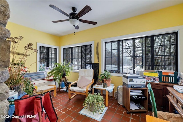 sunroom / solarium featuring plenty of natural light and a ceiling fan