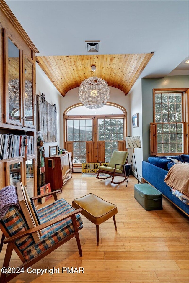 sitting room with a chandelier, light wood-type flooring, wooden ceiling, and lofted ceiling