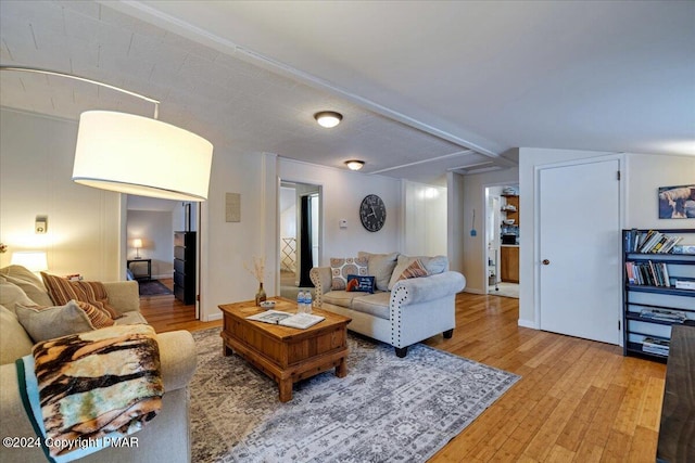 living room with lofted ceiling with beams and hardwood / wood-style flooring