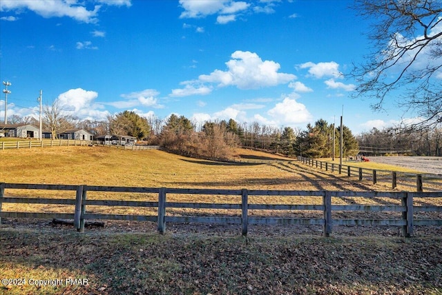 view of yard featuring a rural view and fence