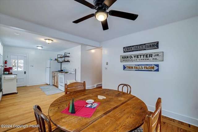 dining space with light wood-style floors, ceiling fan, baseboards, and baseboard heating