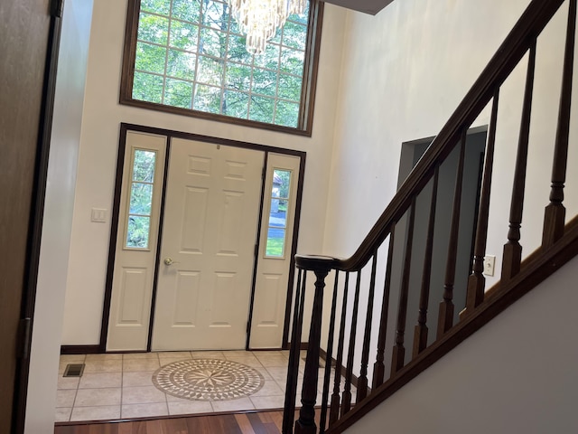 3813 Foxborough Ct, Stroudsburg, PA 18360 - entrance foyer featuring a high ceiling, stairway, plenty of natural light, a chandelier, and light tile patterned flooring
