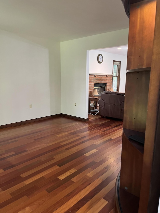 3813 Foxborough Ct, Stroudsburg, PA 18360 - unfurnished living room with dark wood-style flooring and a brick fireplace