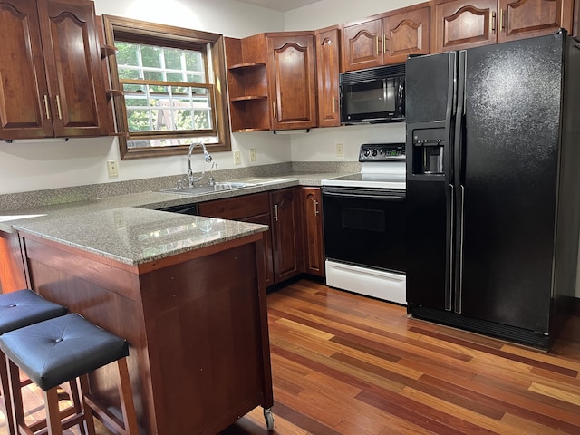 3813 Foxborough Ct, Stroudsburg, PA 18360 - kitchen featuring black appliances, a peninsula, wood finished floors, a kitchen bar, and light stone countertops