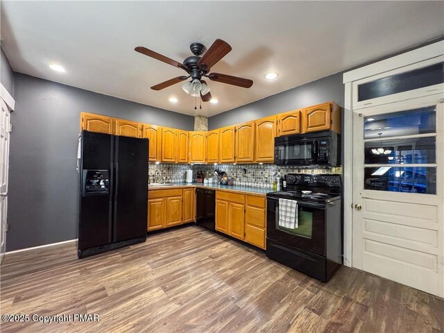 kitchen with hardwood / wood-style flooring, black appliances, ceiling fan, backsplash, and sink