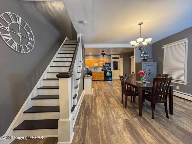 dining space with dark hardwood / wood-style floors and ceiling fan with notable chandelier