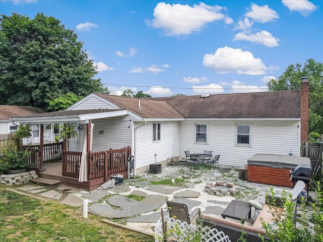 489 Sportsman Club Rd, Nazareth, PA 18064 - rear view of property with a hot tub, a deck, a patio, a chimney, and an outdoor fire pit
