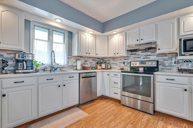 489 Sportsman Club Rd, Nazareth, PA 18064 - kitchen with stainless steel appliances, under cabinet range hood, white cabinetry, and backsplash