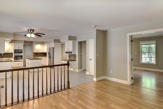 102 Crest Cir E, Stroudsburg, PA 18301 - kitchen with appliances with stainless steel finishes, a ceiling fan, white cabinetry, light wood-style flooring, and dark countertops
