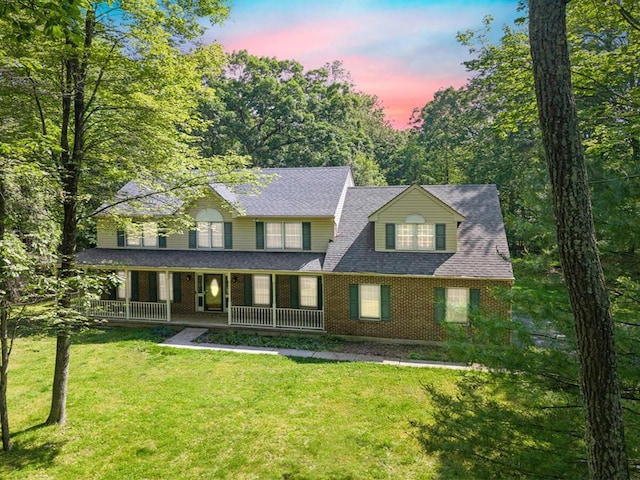 102 Crest Cir E, Stroudsburg, PA 18301 - view of front of property with brick siding, covered porch, a yard, and roof with shingles