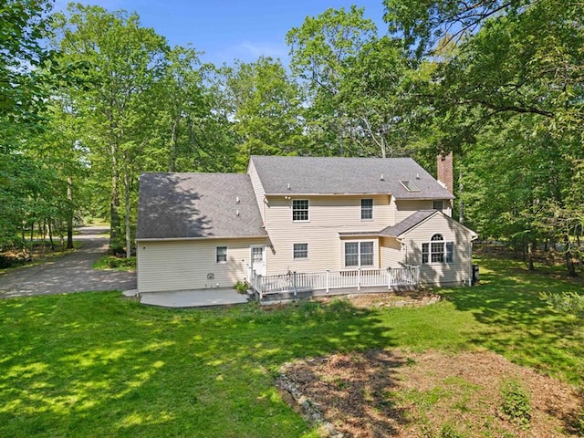 102 Crest Cir E, Stroudsburg, PA 18301 - rear view of house featuring a chimney, a patio area, a yard, and a deck