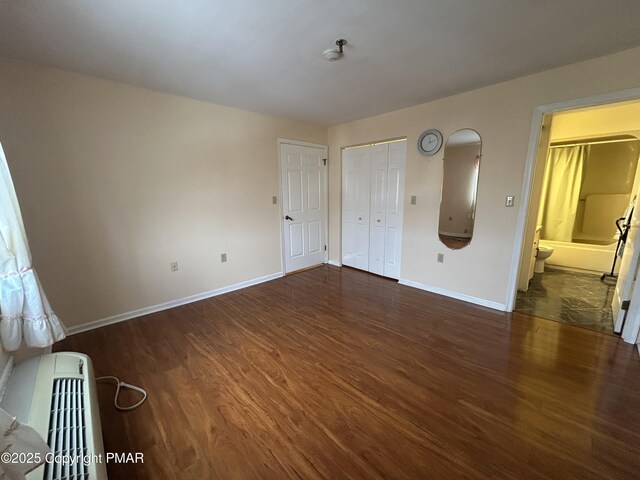 unfurnished room with baseboards and wood finished floors