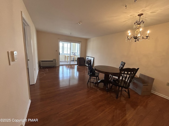 dining room featuring an AC wall unit, a notable chandelier, wood finished floors, and baseboards