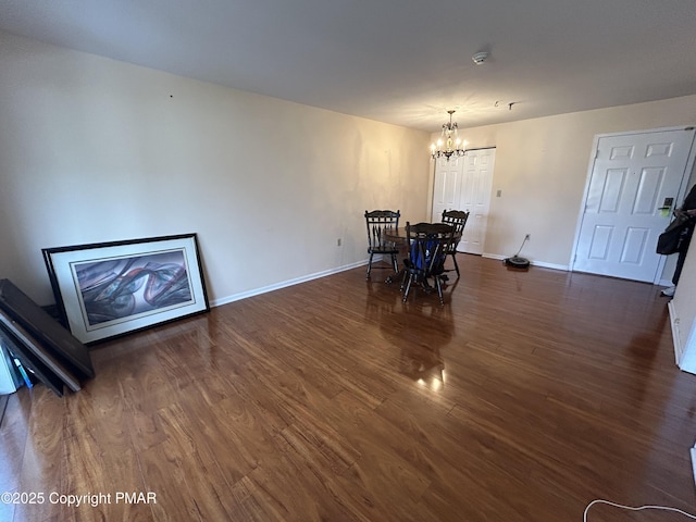 dining space with a notable chandelier, baseboards, and wood finished floors