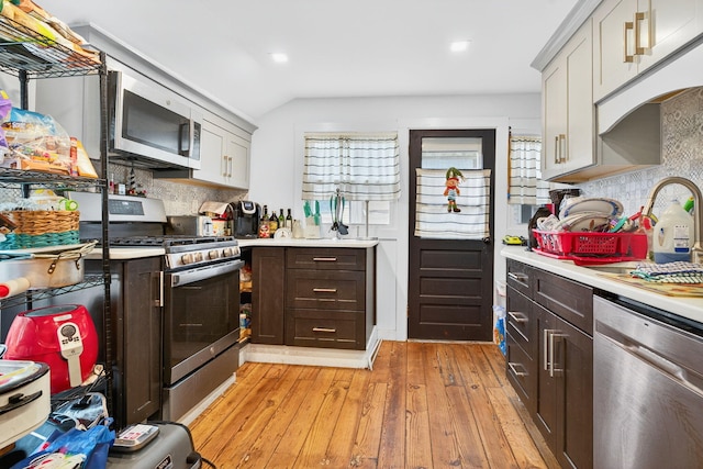 10 S Broad St, Bangor, PA 18013 - kitchen featuring stainless steel appliances, light countertops, tasteful backsplash, light wood-style flooring, and vaulted ceiling