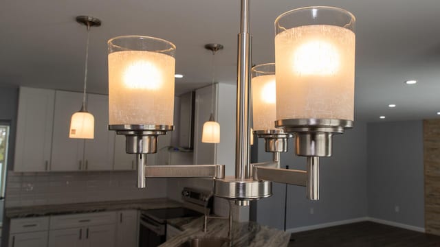room details featuring stainless steel electric range oven, white cabinets, dark stone countertops, recessed lighting, and decorative backsplash