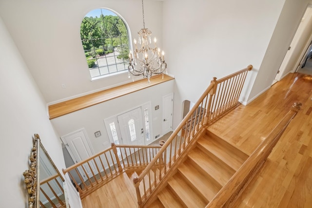 1376 Buck Ridge Dr, Stroudsburg, PA 18360 - stairs featuring a towering ceiling, a chandelier, and wood finished floors