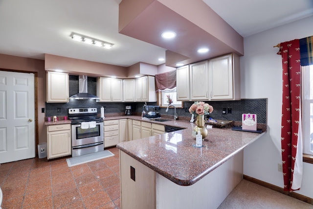 kitchen with tasteful backsplash, stainless steel electric range oven, a peninsula, wall chimney exhaust hood, and a sink