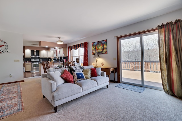 living area with light colored carpet and baseboards