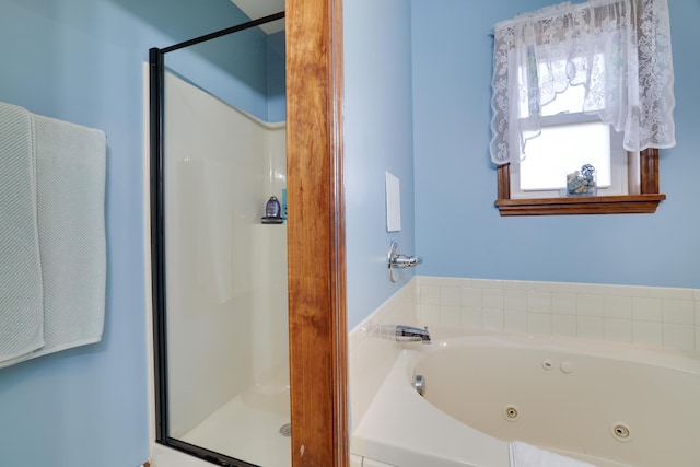 full bath featuring a jetted tub and a stall shower