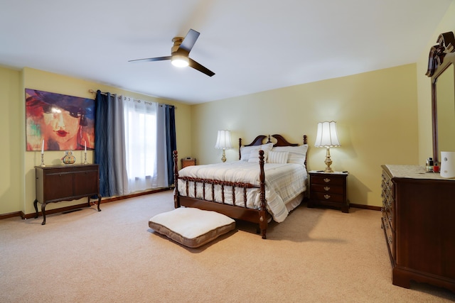 bedroom featuring baseboards, light colored carpet, and a ceiling fan