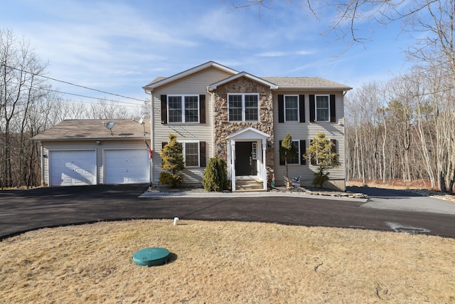 colonial inspired home with stone siding and a garage