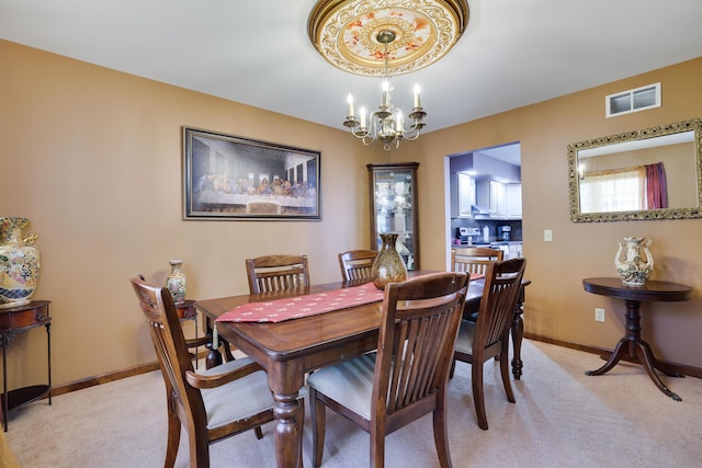 dining area featuring a chandelier, visible vents, light carpet, and baseboards