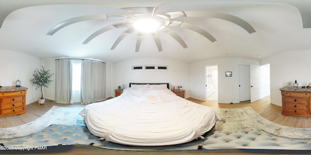 bedroom featuring vaulted ceiling, light hardwood / wood-style floors, and ceiling fan