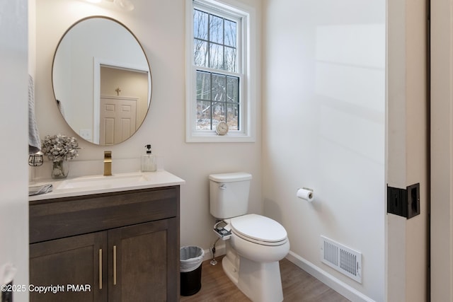 bathroom with vanity, toilet, and wood-type flooring