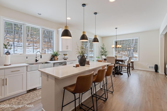 kitchen featuring white cabinetry, decorative light fixtures, and sink