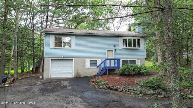 619 Rimrock Rd, Bartonsville, PA 18321 - view of front facade with a garage, asphalt driveway, and a chimney