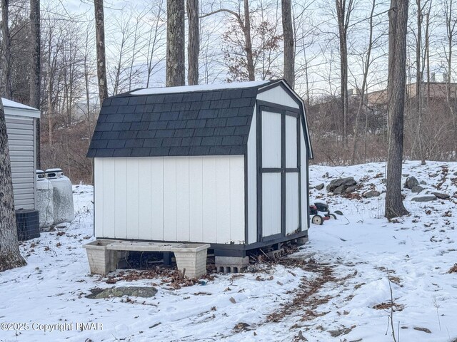 snow covered structure with a storage unit and an outdoor structure