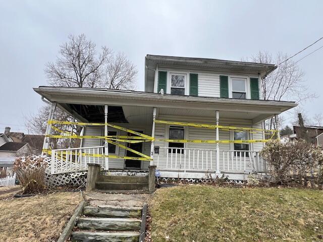 view of front of home with a porch and a front yard