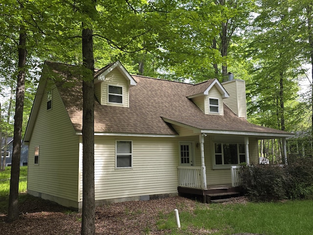131 Pine Dr, Pocono Lake, PA 18347 - view of front of home featuring a chimney, roof with shingles, covered porch, and crawl space