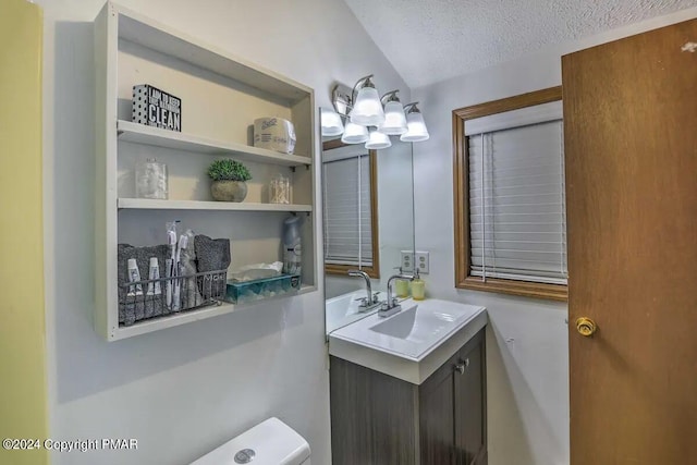 half bathroom featuring toilet, a textured ceiling, and vanity