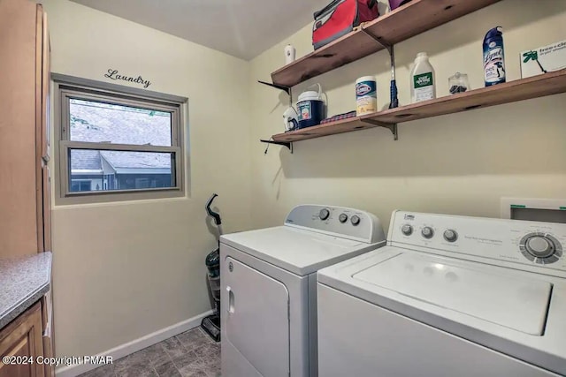 clothes washing area with separate washer and dryer, cabinet space, and baseboards