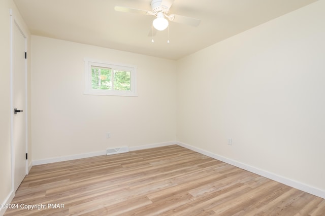 empty room with light wood-style floors, visible vents, baseboards, and a ceiling fan