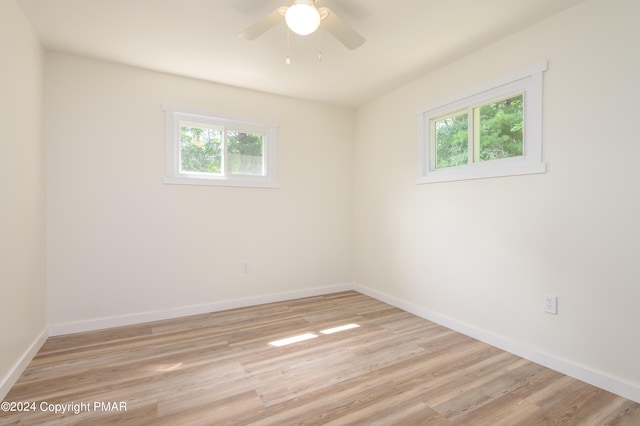 empty room featuring light wood-style floors, ceiling fan, and baseboards