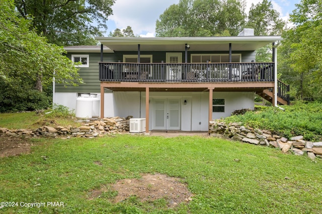 rear view of property with a yard, a chimney, and a wooden deck