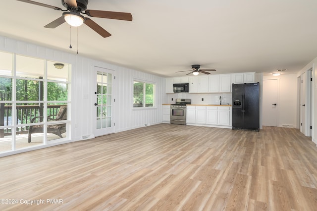 kitchen with light wood finished floors, light countertops, decorative backsplash, white cabinets, and black appliances