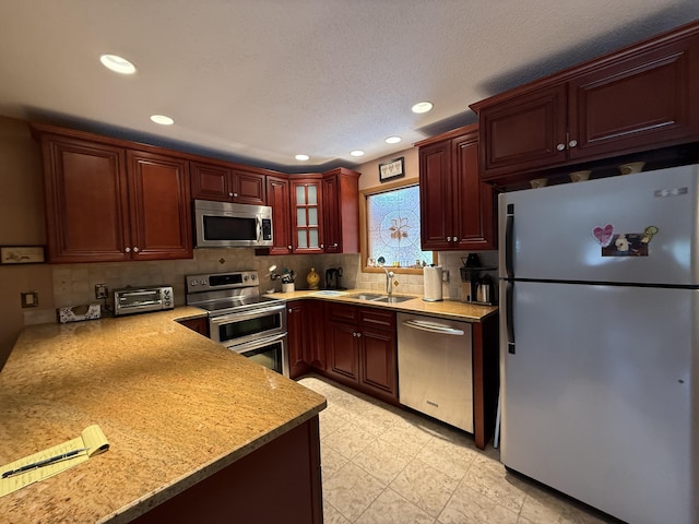 343 Echo Lake Rd, Tobyhanna, PA 18466 - kitchen with light countertops, appliances with stainless steel finishes, reddish brown cabinets, and a sink
