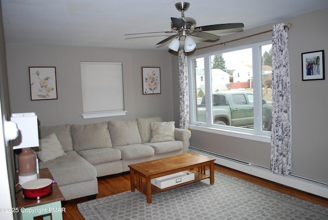 living room featuring hardwood / wood-style floors, ceiling fan, and baseboard heating