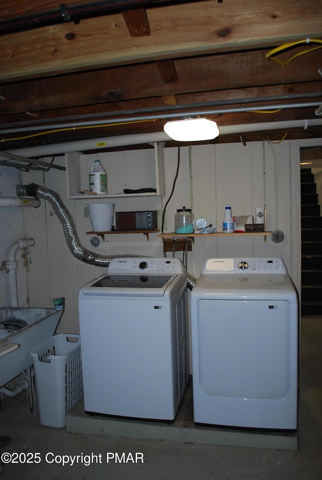 clothes washing area with washing machine and dryer and sink