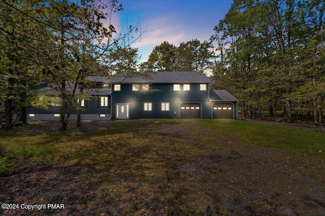 view of front facade featuring a lawn, a garage, and driveway