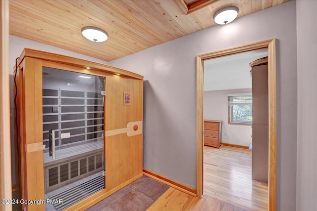 interior space with wooden ceiling, baseboards, and wood finished floors