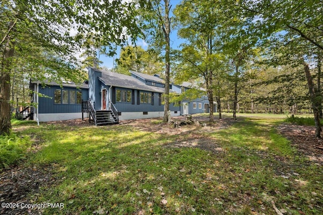 view of front of house with entry steps, a front yard, and crawl space