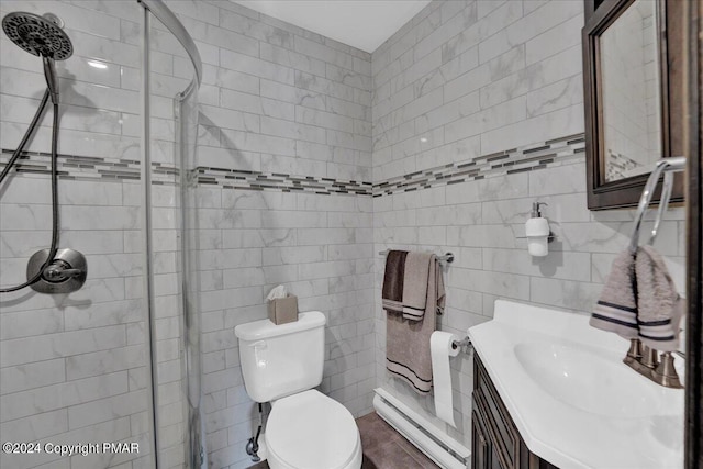 full bath featuring a baseboard heating unit, toilet, vanity, and a stall shower