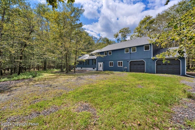 back of house with a yard, a garage, and driveway