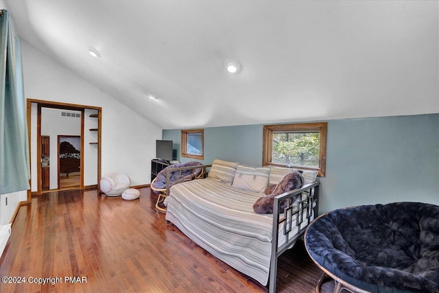 bedroom featuring vaulted ceiling, baseboards, visible vents, and wood-type flooring