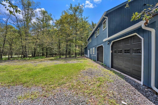 view of yard featuring a garage and driveway